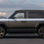 Side view of a silver-and-charcoal two-door SUV rendering with a rear-mounted spare tire.